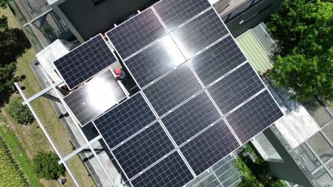 aerial top down shot of workers installing solar panels on rooftop during sunny day