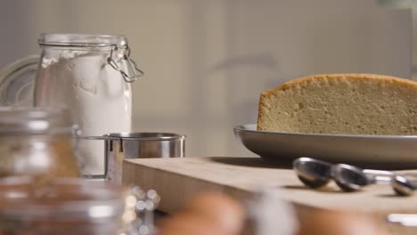 close up of kitchen at home with freshly baked cake on plate next to ingredients