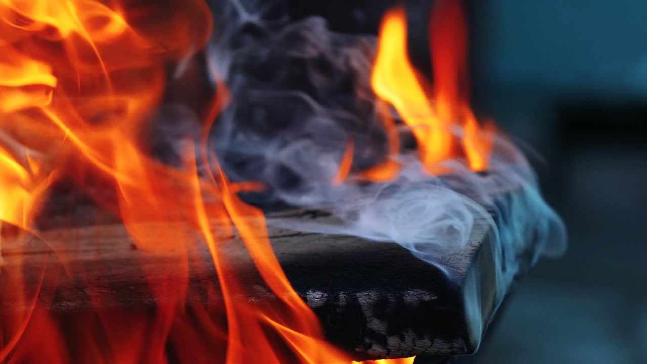 a wooden board is smoldering under the influence of a hot flame