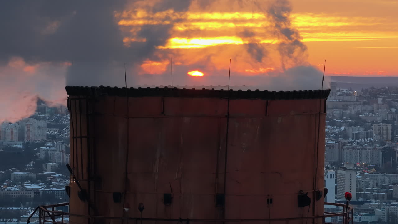 Aerial drone view of a working thermal power station in Chisinau at sunset. Steam and smoke coming from pipes. Moldova