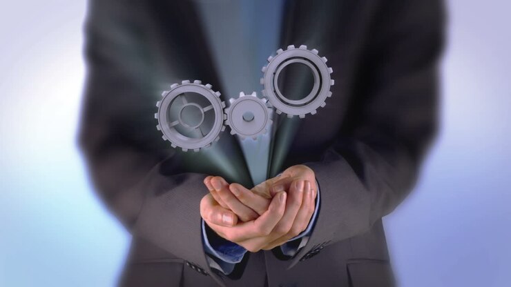 Businessman presenting cogs and wheels graphic