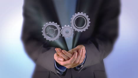 businessman presenting cogs and wheels graphic