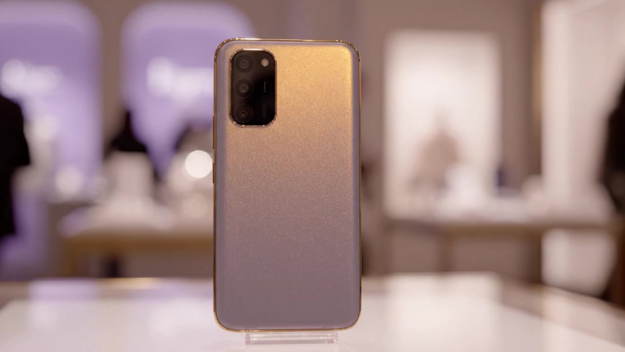 Elegantní moderní smartphone s leštěnými zády, předvádějící svůj podmanivý design, elegantně spočívá na bílém povrchu ve stylovém prostředí