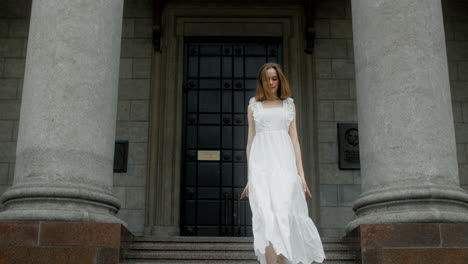ballet dancer in white dress at architectural building