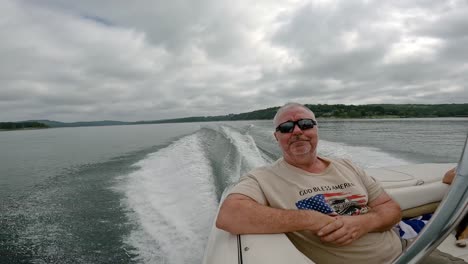 el hombre disfruta sentado en la parte trasera del barco deportivo navegando en el lago table rock en las montañas ozark de missouri, ee.uu.