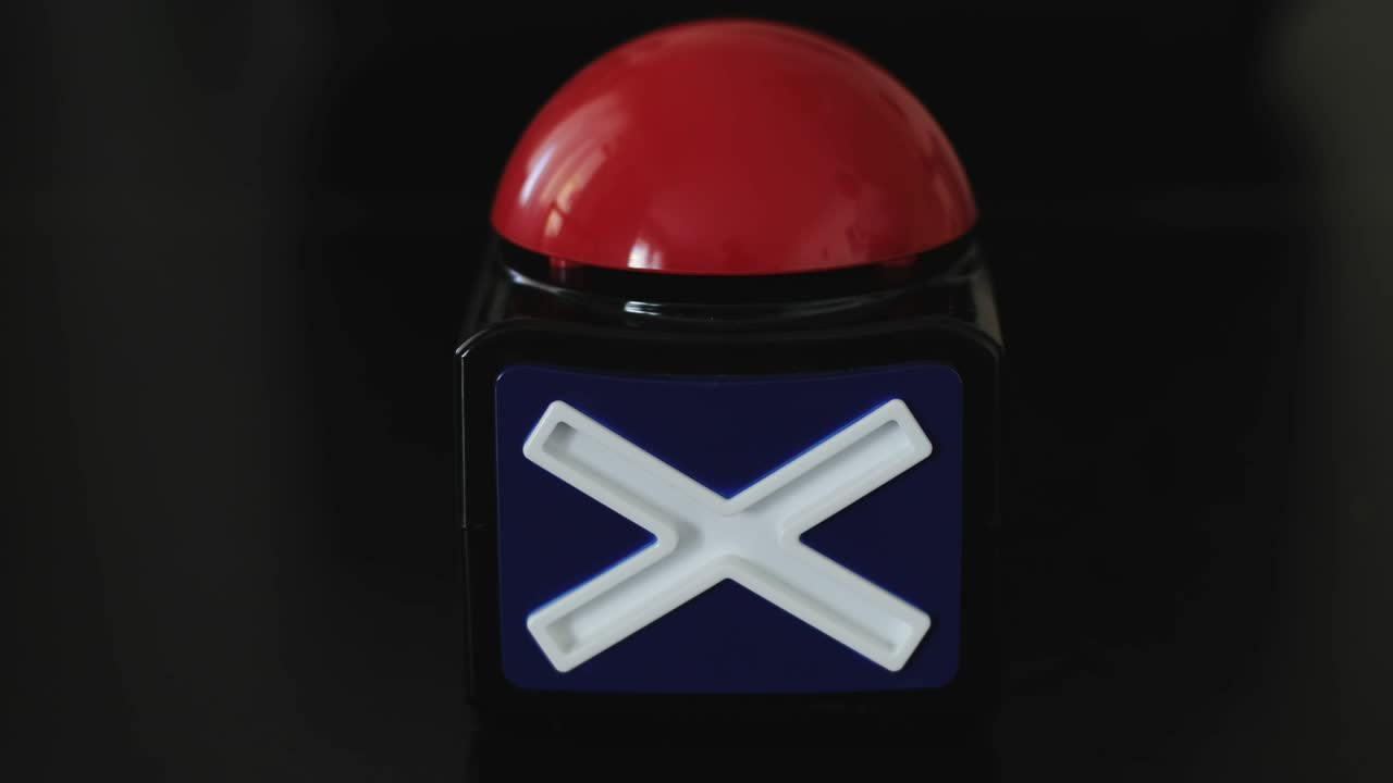 gran botón rojo con la inscripción de parar siendo empujado.