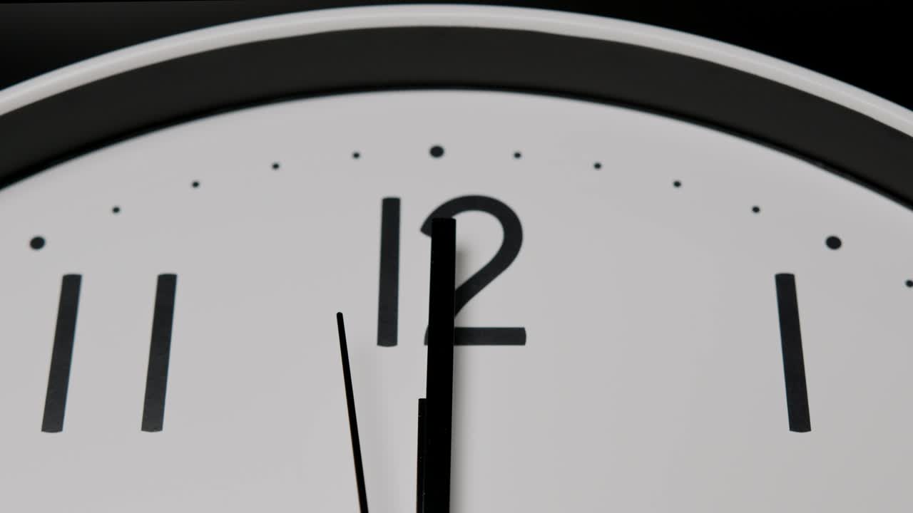 Close up, The short hand and the long hand point to the number twelve .