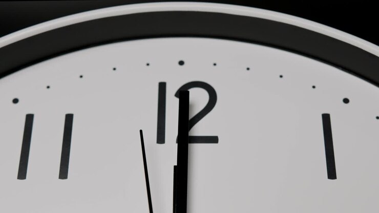 Close up, The short hand and the long hand point to the number twelve .