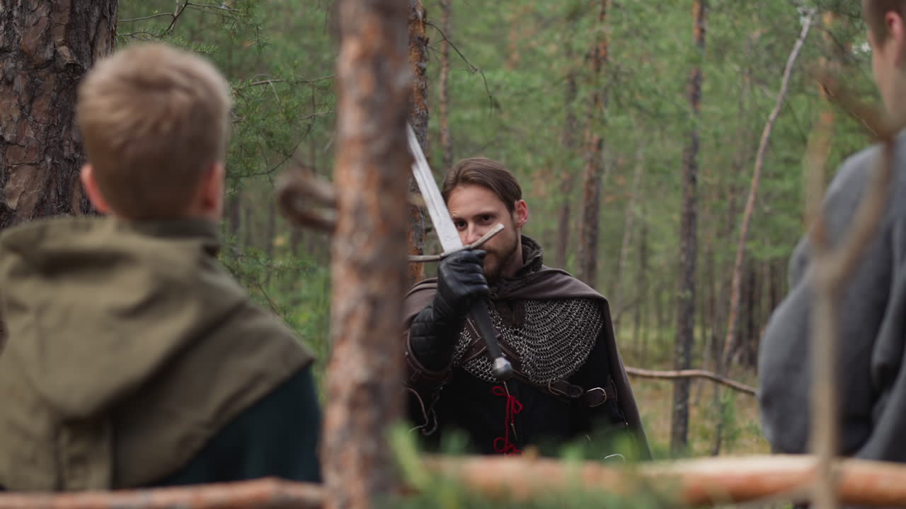 el caballero enseña a los niños a luchar con espadas.