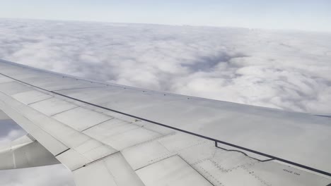 the view from an airplane over wing to the wast clouds