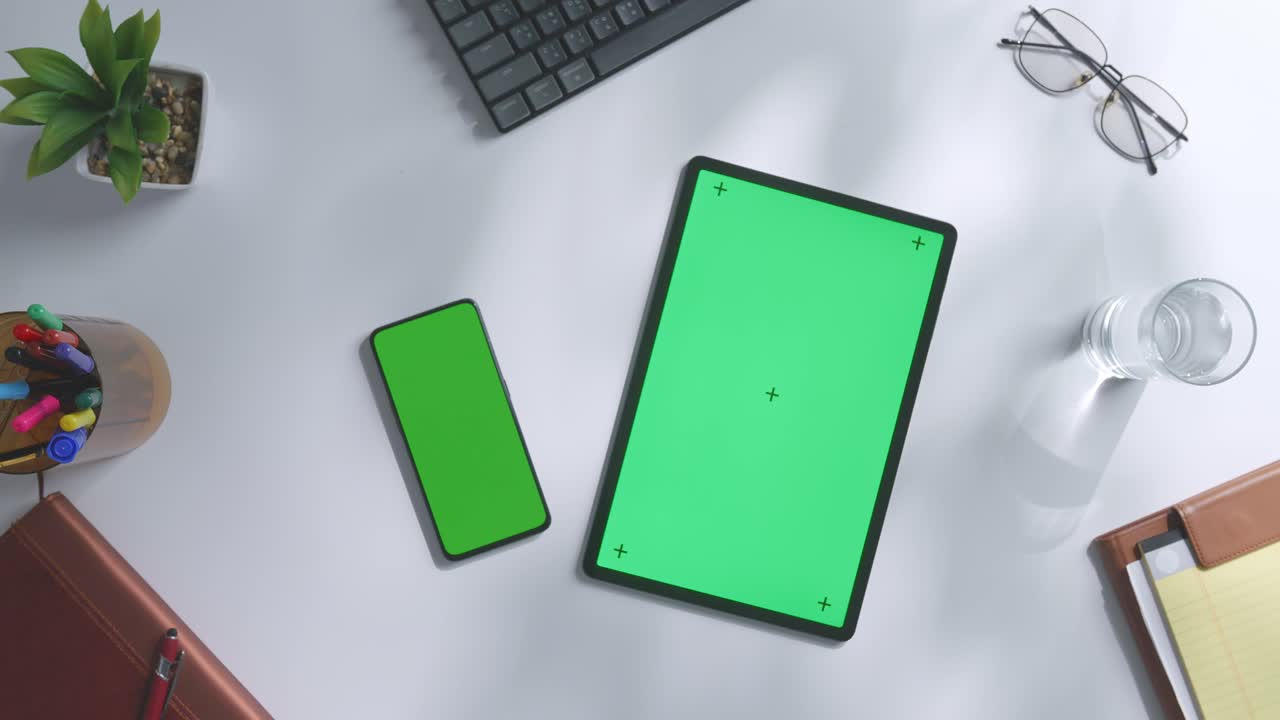 espacio de trabajo de oficina con pantallas verdes de tabletas y teléfonos