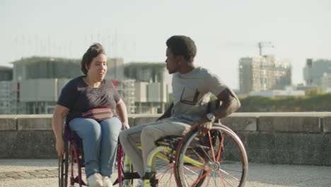 Happy-couple-using-wheelchairs-dancing-and-whirling-outdoors