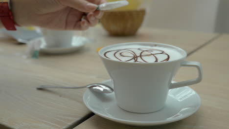 adding sugar to the coffee served in cafe