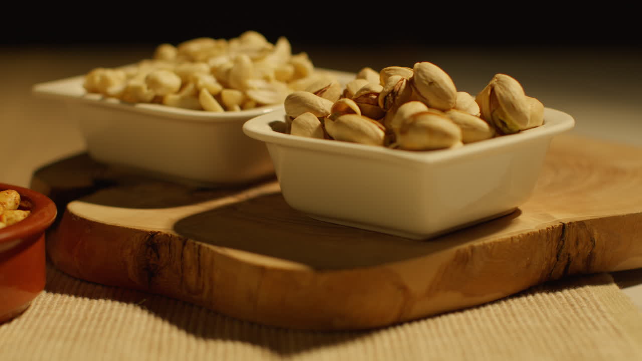 Close Up Of Bowls Of Cashews Dry Roasted Peanuts And Pistachio Nuts In Studio 3