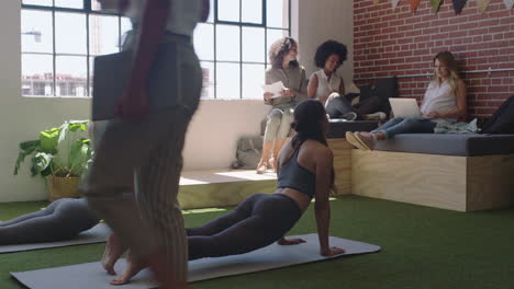 young business women practice yoga meditation together in office doing cobra pose enjoying mindfulness exercise relaxing on lunch break
