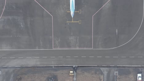 avión de negocios de lujo estacionado en asfalto de hormigón en el aeropuerto, antena de arriba hacia abajo