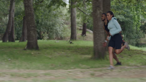 fit couple running fast outdoors in a forest