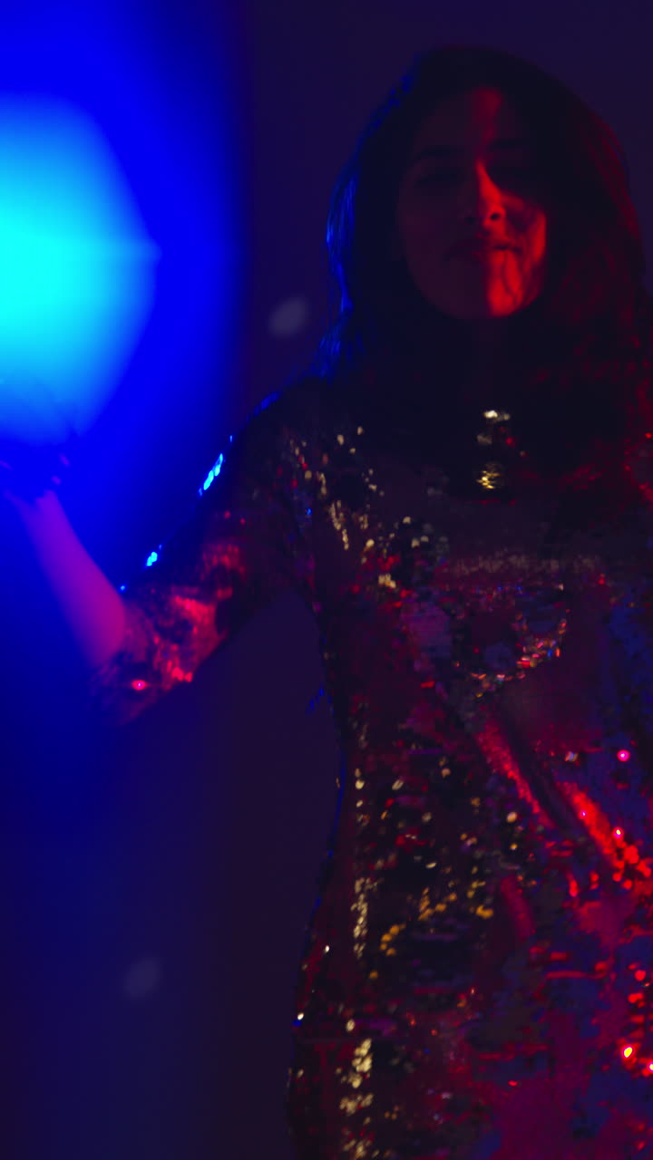 video vertical de una mujer en un bar de discoteca o discoteca bailando con luces brillantes en el fondo 2