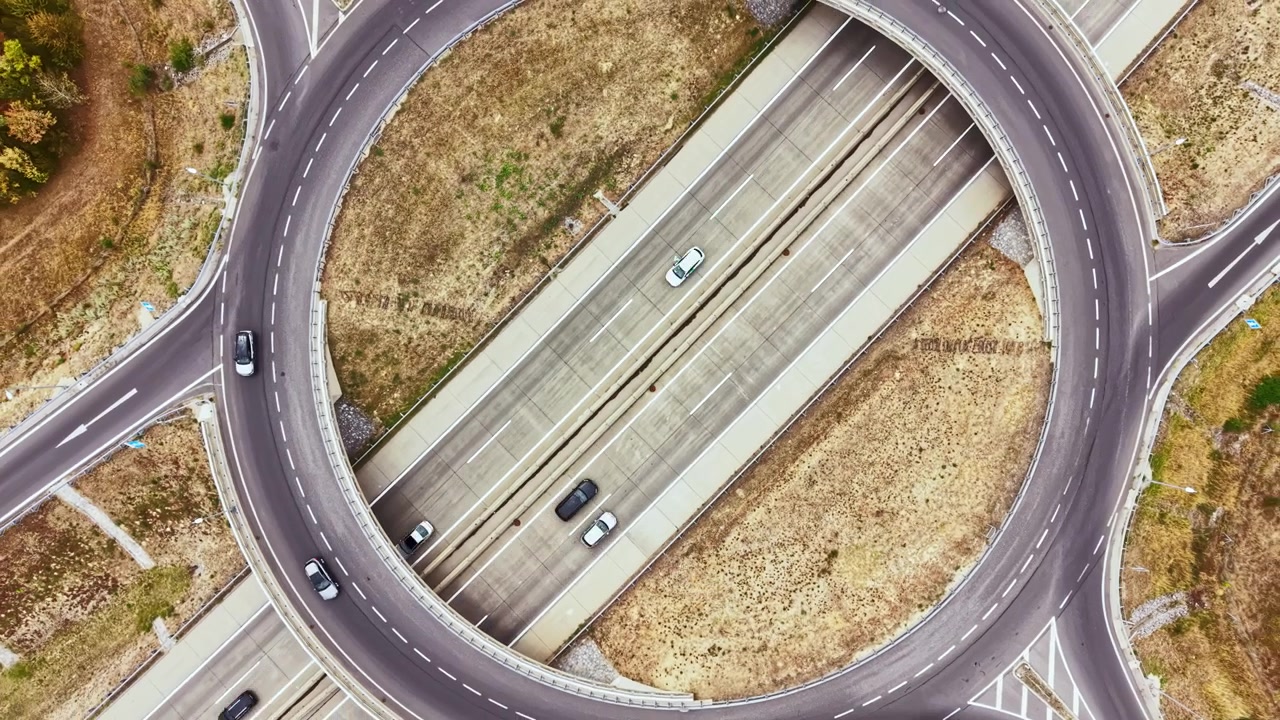 View of a roundabout with a truck on a road during the day, showing the design and traffic flow in an urban area