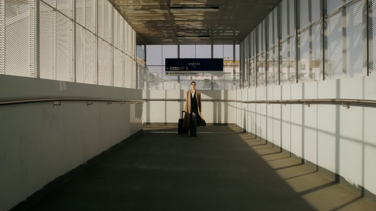 mujer caminando a través de un puente del aeropuerto y la estación de tren