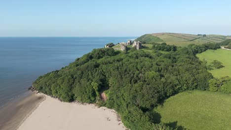 An-aerial-view-of-the-of-Llansteffan-Castle-in-Carmarthenshire,-South-Wales,-on-a-sunny-morning-with-a-clear-blue-sky