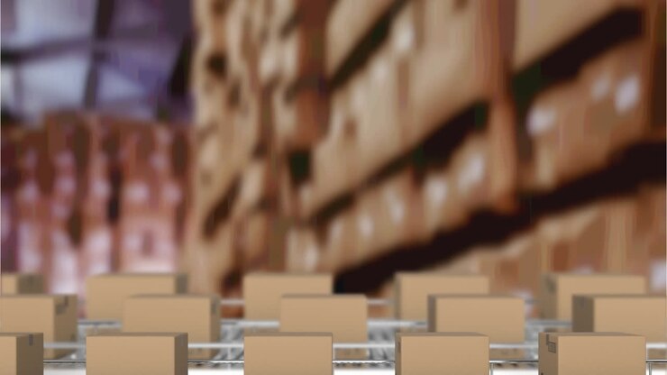 Multiple delivery boxes on conveyor belt against warehouse in background