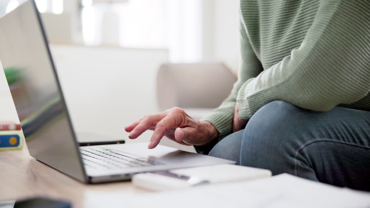 Person hands, calculator and laptop on sofa