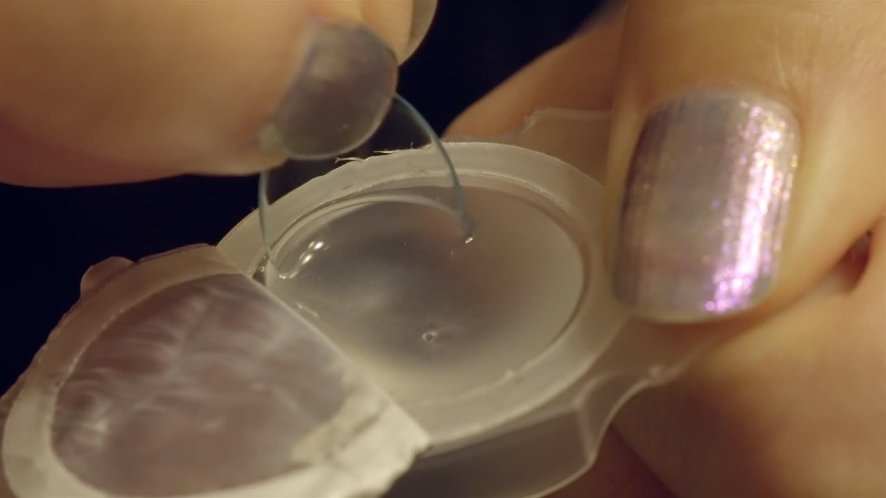 Close-up of Hand Removing Contact Lens from Sterile Blister