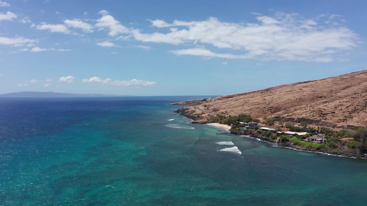 Wide aerial shot flying over the crystal clear waters of Maalaea Bay along the coastline of West Maui in Hawai'i