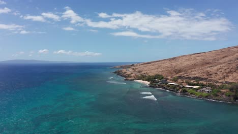 wide aerial shot flying over the crystal clear waters of maalaea bay along the coastline of west maui in hawai'i