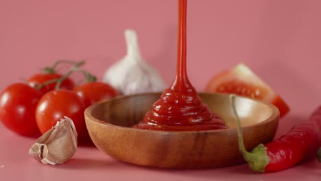 tomato sauce pours on a wooden plate.