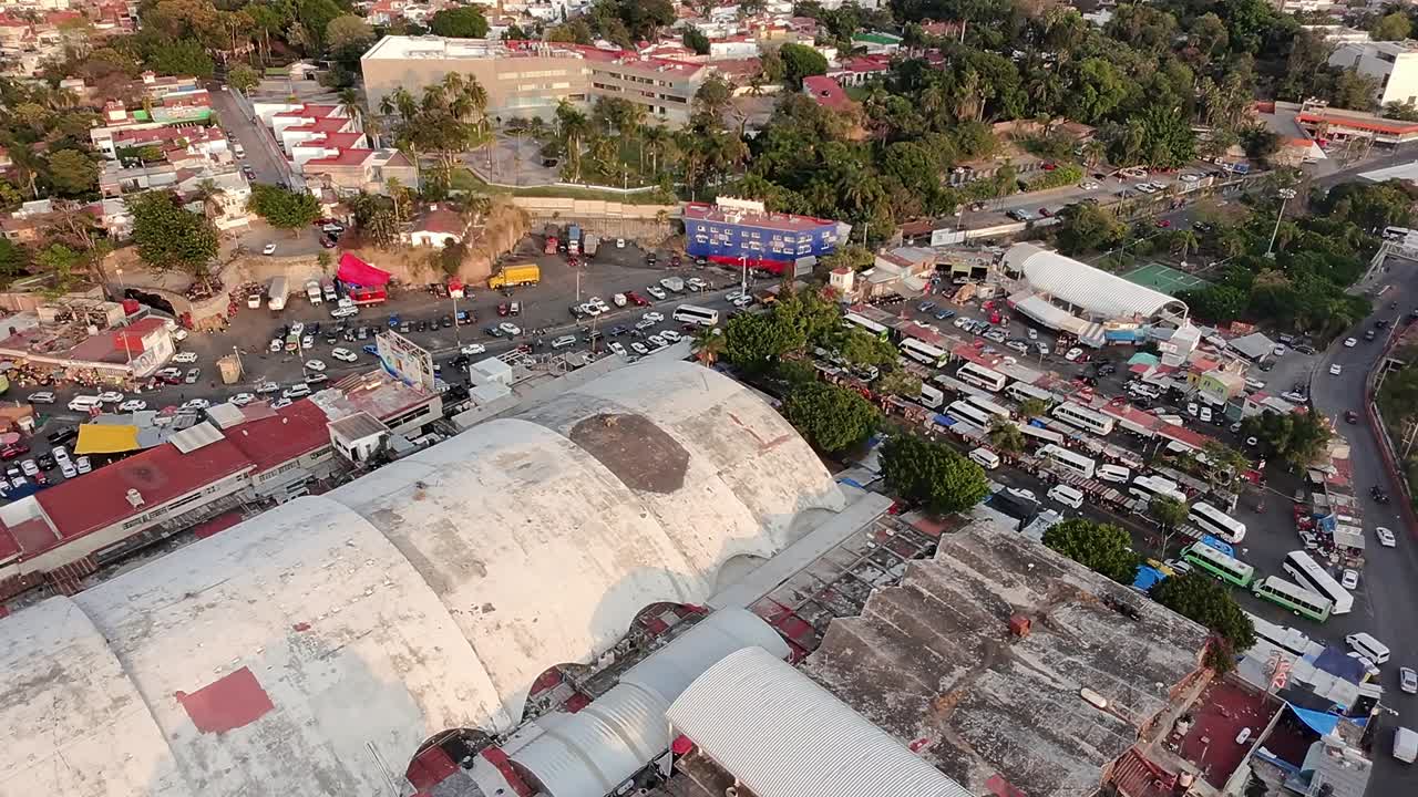 Mercado Adolfo López Mateos in Cuernavaca, Mexico, showing bus terminals, market stalls, and bustling urban activity. Drone aerial view