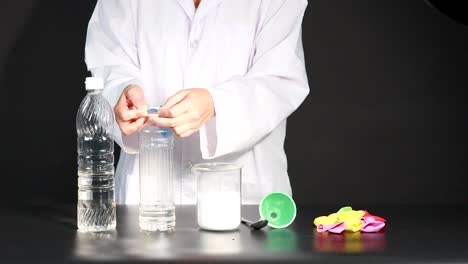 un científico demuestra una reacción química inflando un globo usando vinagre y bicarbonato de sodio en un entorno de laboratorio
