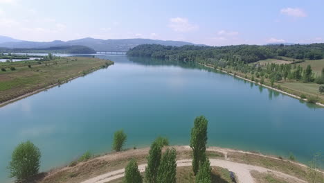 aerial approach of the coastline of a lake in the tuskany in italy on a sunny day