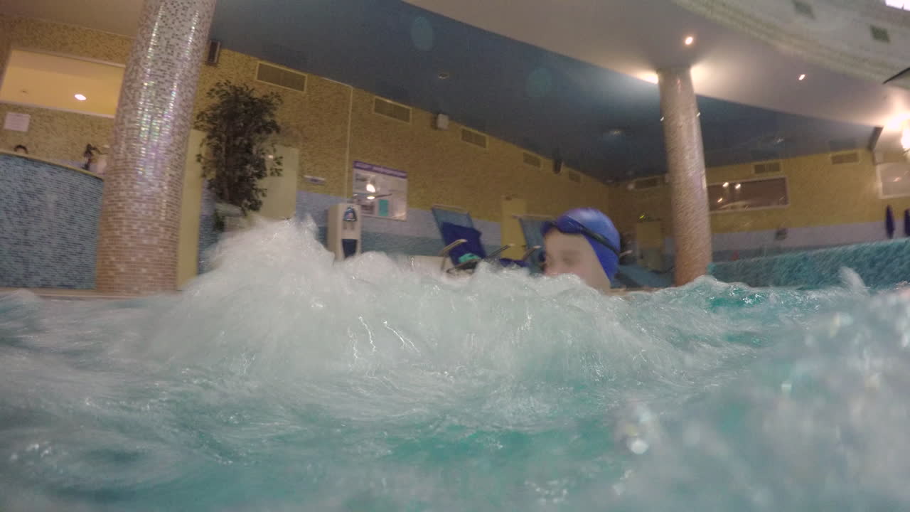 아이 와 함께 수위 마사지 수영장 에 있는 어머니