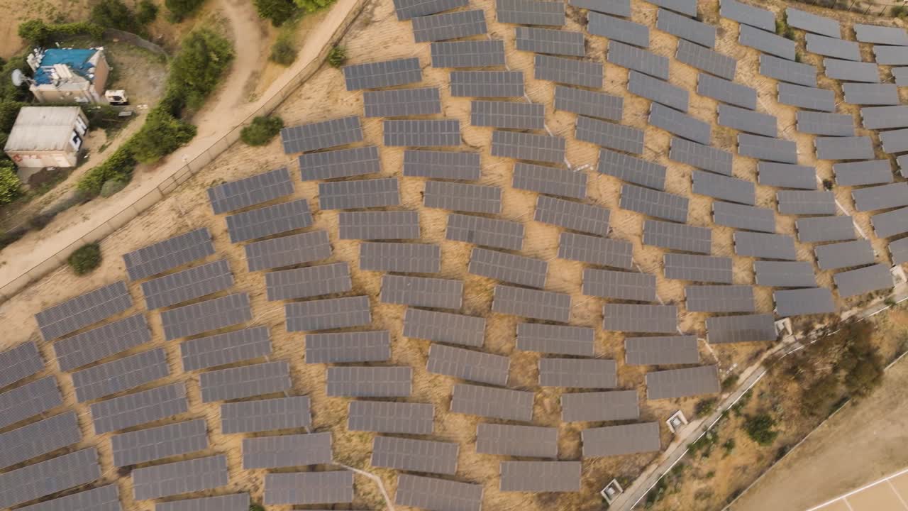 drone view of a solar farm with many panels in Southern California with mountains in the distance