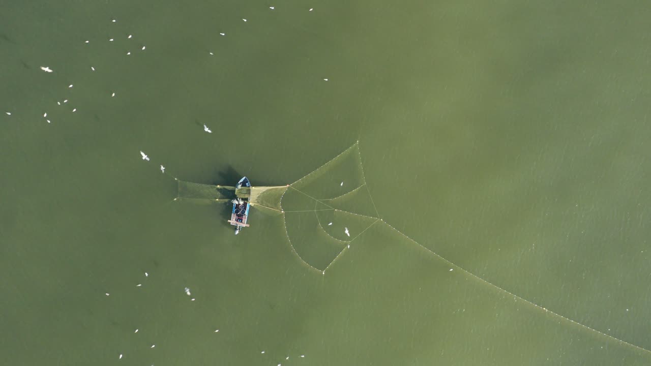 공중:갈매기가 물고기를 찾아 날아다니며 푸른 발트해에서 그물을 던지는 어부들