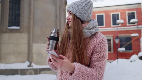 Traveler-woman-with-mobile-phone,-looking-for-route-using-mobile-map-application,-drinking-hot-drink