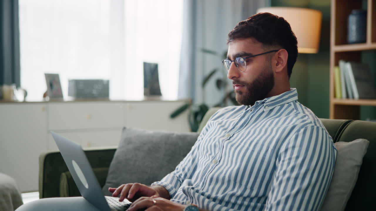 hombre trabajando en una computadora portátil en casa