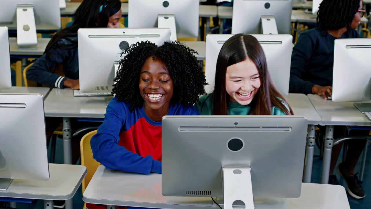 High-angle shot of diverse students collaborating on a computer project in a classroom