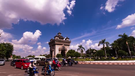 patuxai monument vientiane with fluffy clouds and city traffic