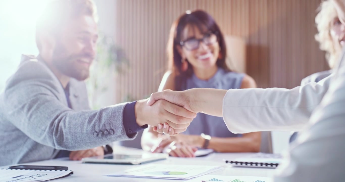 Professionisti aziendali che si stringono la mano durante una riunione in un ufficio moderno