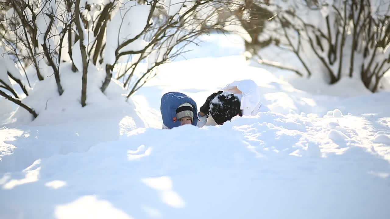 Mother with son walking on snow. Little boy with mother walking in snowy winter day