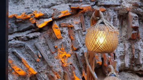 rustic bamboo lantern hanging on a stone wall