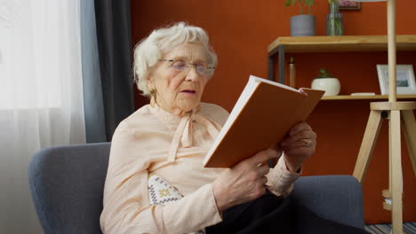 elderly woman reading book at home