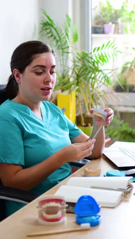 a dental technician dentist working with prostheses in a laboratory with wax on a jaw model.