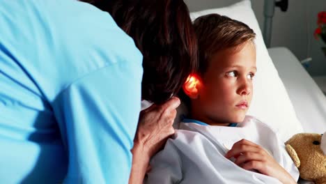 Female-doctor-examining-patient-ear-with-otoscope