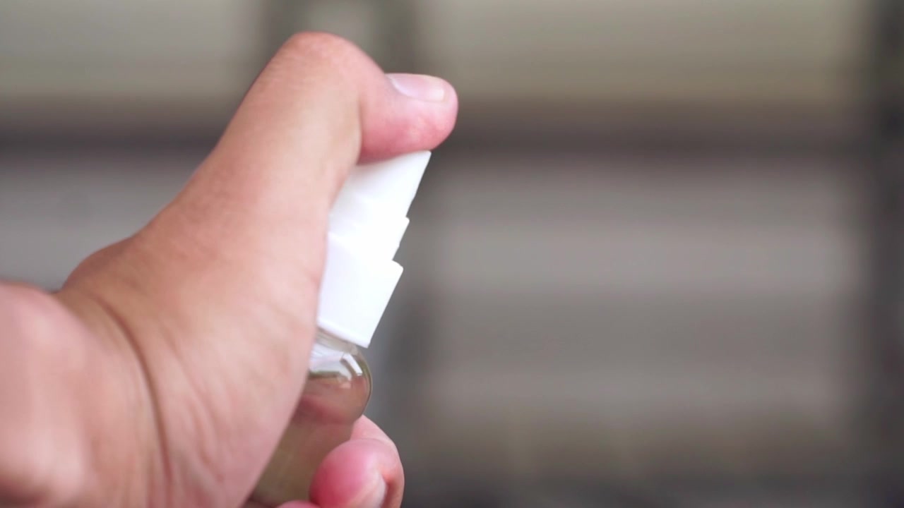 Hand spraying sanitizer for hygiene, personal protection, sanitation practice, closeup health detail.