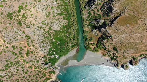 Toma-Aérea-De-Arriba-Hacia-Abajo-Del-Río-Kourtaliotis-Que-Fluye-Entre-Montañas-En-La-Playa-De-Preveli