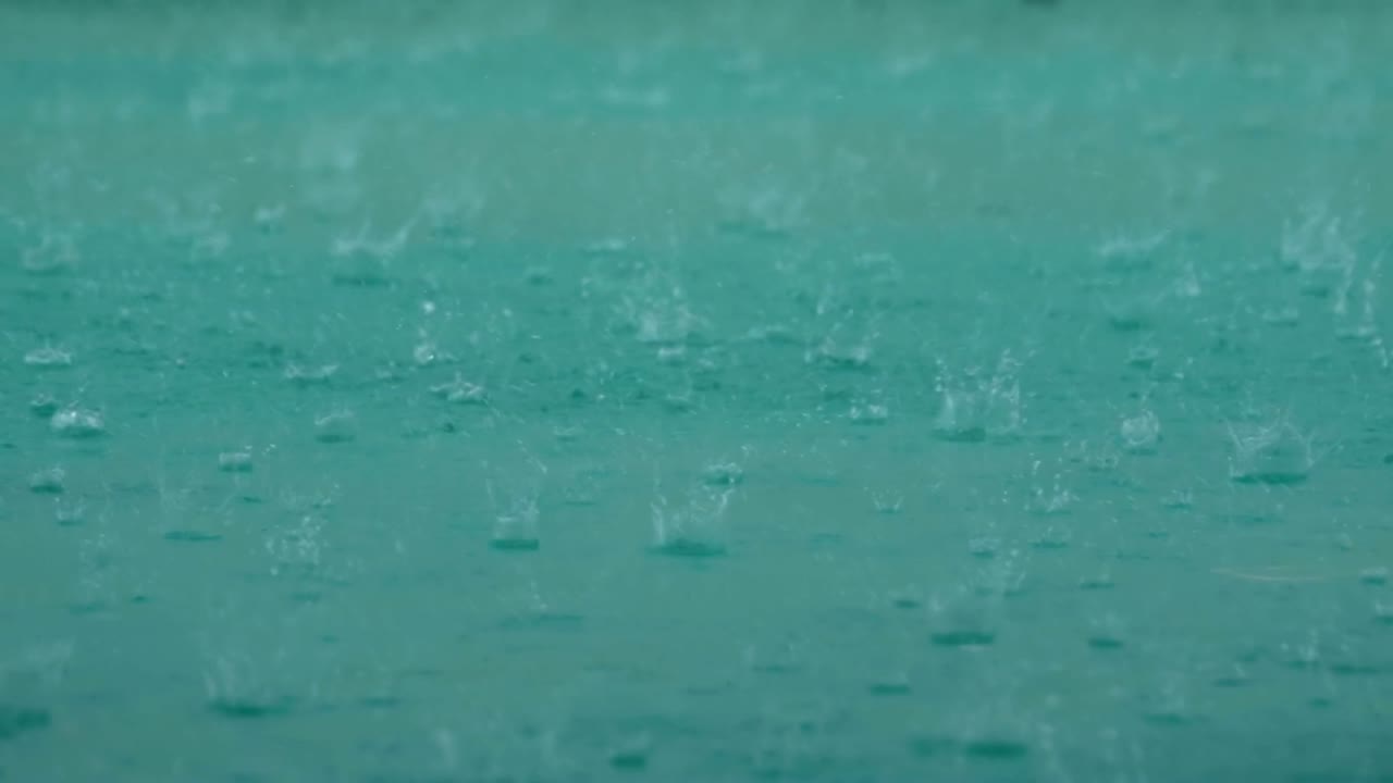 grandes gotas de lluvia caen en un charco durante una tormenta de lluvia. gotas de agua